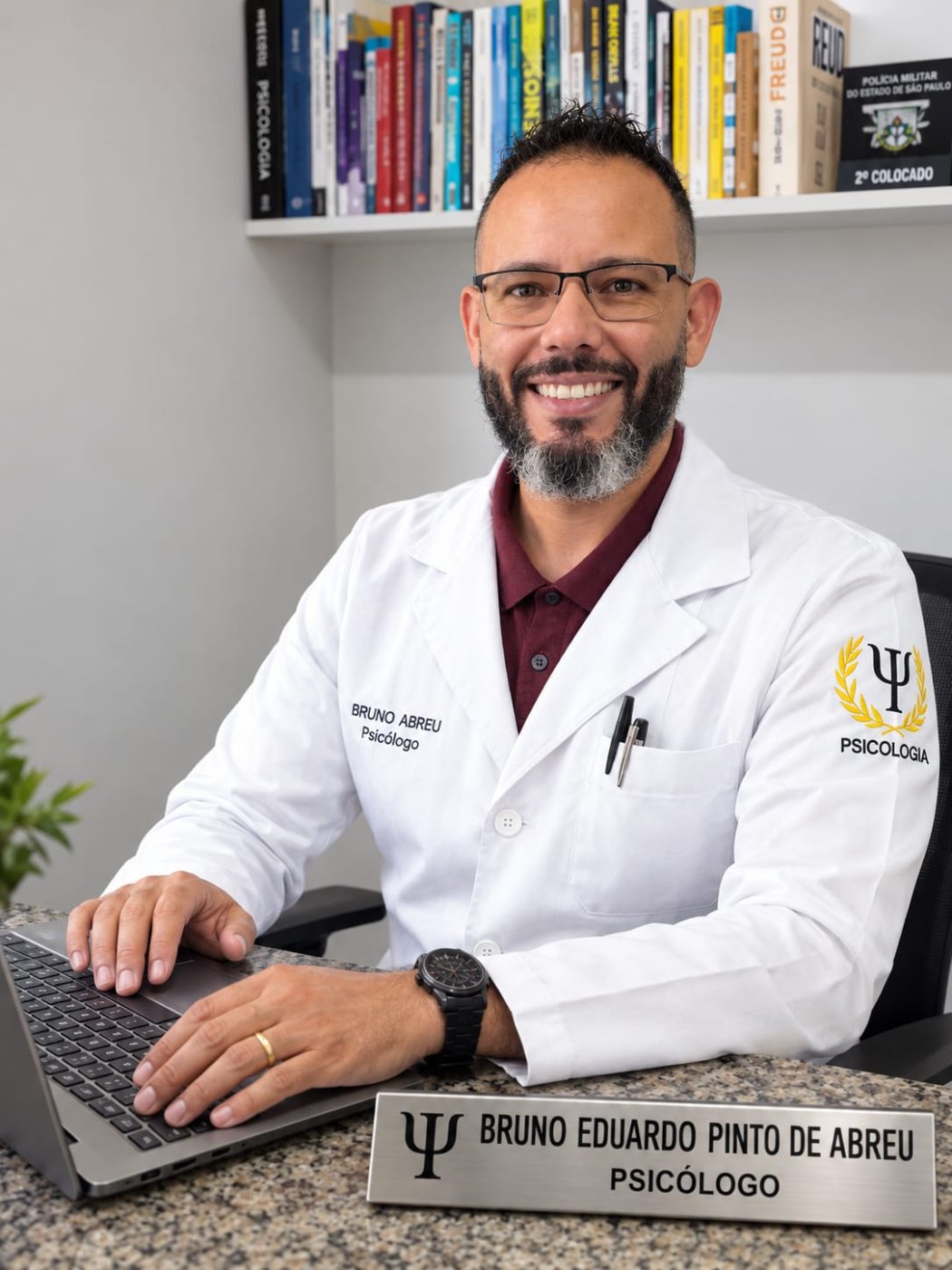 Bruno Abreu no consultório, à mesa, com estante de livros ao fundo